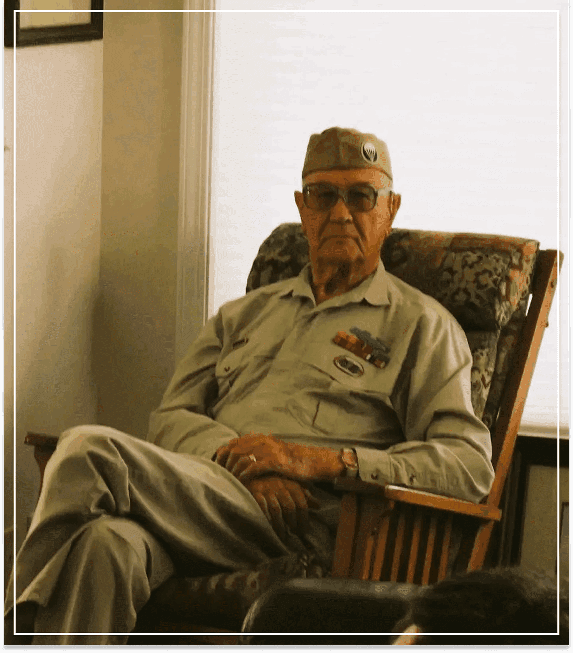 Elderly man sitting in a cozy chair by the window.